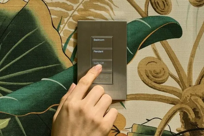 A Lutron keypad on patterned wallpaper