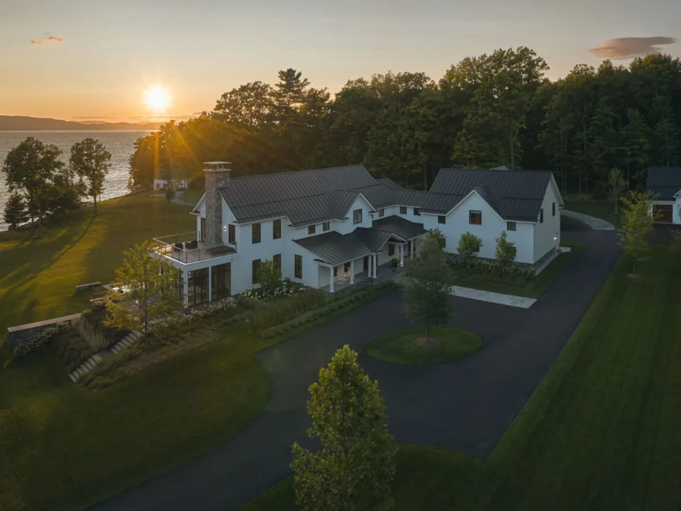 Lakeside Retreat at sunset, the sun setting over Lake Champlain beyond the lawn